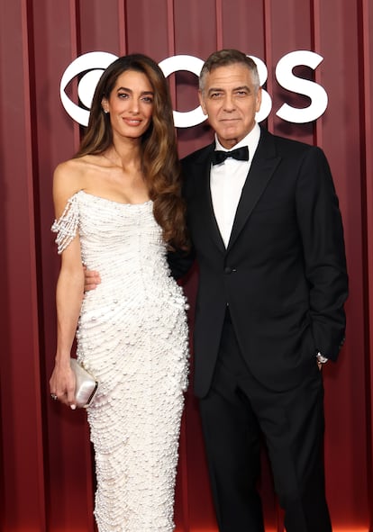 Amal Clooney, con vestido blanco de Tamara Ralph, acompañada de su marido George Clooney.