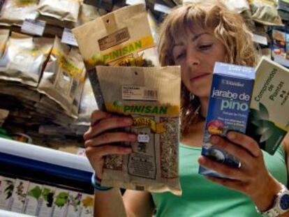 Una mujer observa productos naturales en una parafarmacia.