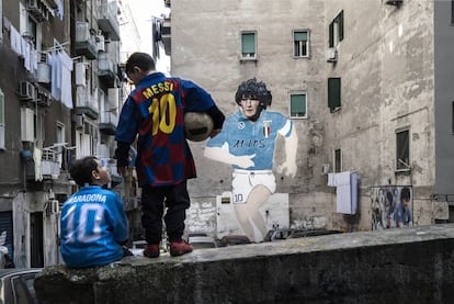 Dos niños lucen las camisetas de Maradona y Messi en el barrio de Forcella (Nápoles).