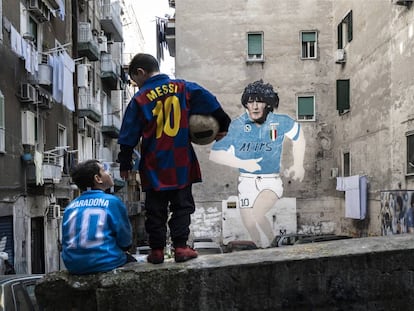 Dos niños lucen las camisetas de Maradona y Messi en el barrio de Forcella (Nápoles).