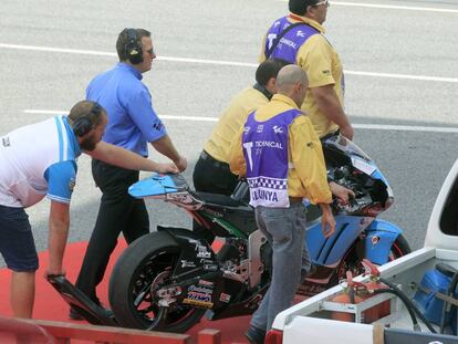 Operarios retiran la moto de Luis Salom. 