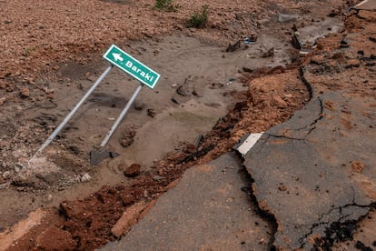 A sign buried in mud next to a flood-ravaged road in Maalimin, Kenya, in November 2023.
