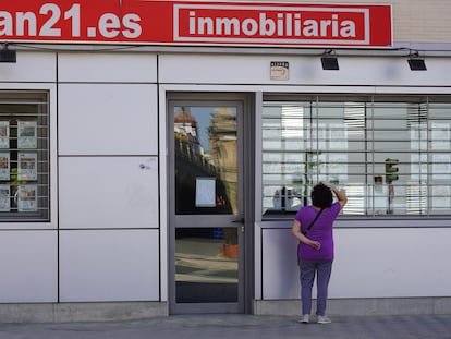 Una mujer mira el escaparate de una inmobiliaria en Sevilla, el pasado 4 de mayo.