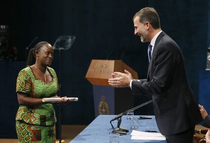 El rey Felipe VI tras hacer entrega del Premio Príncipe de Asturias a la Concordia 2014 a la periodista congoleña Caddy Adzuba.