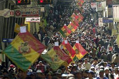 Cientos de bolivianos marchan hoy con banderas del país por las calles del centro de La Paz.