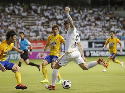 Fernando Torres (derecha), del Sagan Tosu, lanza ante la presión de los jugadores del Vegalta Sendai.