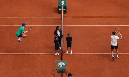 Jannik Sinner (a la izquierda), de Italia, y Carlos Alcaraz, de España, calientan en la pista antes del lanzamiento de moneda para elegir quién sirve primero.