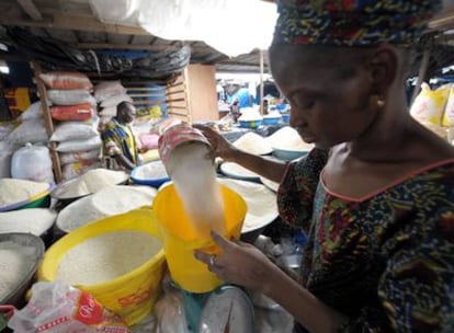 Una mujer vende cereales en el mercado de Abidjan en Costa de Márfil, mientras los líderes mundiales discuten en Roma las formas para combatir la crisis alimentaria