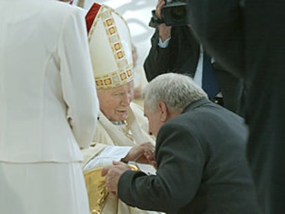 El ex presidente polaco Lech Walesa besa la mano del Papa tras la misa celebrada ayer en Cracovia.