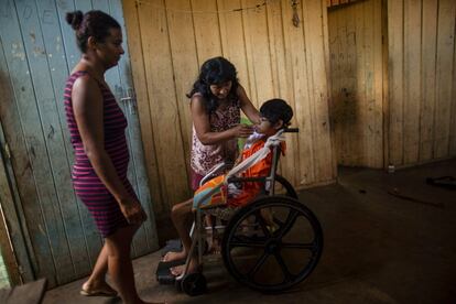 Una enfermera mira a una mujer indígena darle la medicina a su hija discapacitada de 17 años en el campamento tribal de Laranjal, en tierras indígenas de Arara, estado de Para, en la selva tropical del norte de Brasil, el 15 de marzo de 2019.  