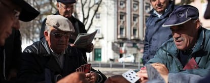 Aposentados portugueses jogam cartas em um parque de Lisboa.