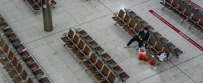 Un viajero ataviado con una mascarilla protectora, en una estación de tren de Hong Kong.