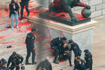 Efectivos de la Policía Nacional detienen a unos activistas de Rebelión Científica que lanzaron pintura roja en la Puerta de Los Leones del Congreso, este jueves en Madrid.
