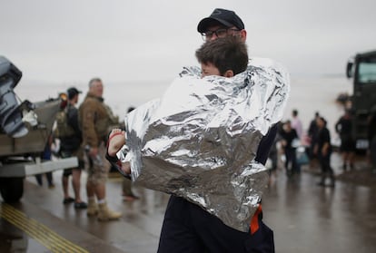 Un rescatista lleva a un niño después de ser rescatado de las inundaciones en Porto Alegre. 