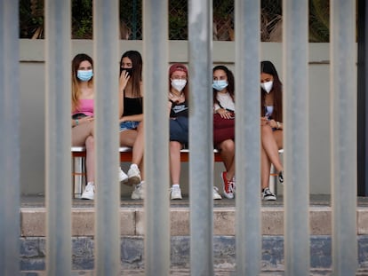 Jóvenes con mascarillas esperan el tren en Canet de Mar (Barcelona), en verano de 2021.