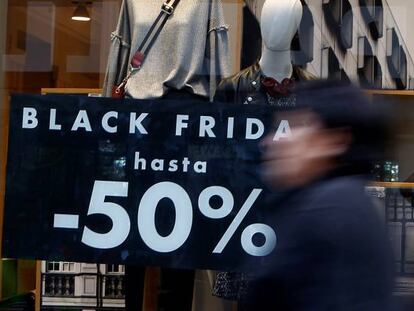 Viandantes pasan por delante de un escaparate que anuncia descuentos con motivo del Black Friday.