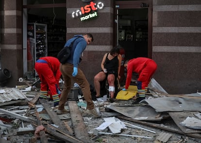 Personal médico atiende a un residente en el lugar de un edificio de apartamentos alcanzado por ataques rusos en Kiev.
