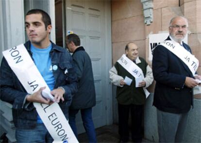 Tres hombres entregan papeletas con el <i>sí</i> por fuera de un colegio electoral de Estocolmo esta mañana.
