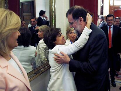 Soraya Sáenz de Santamaría saluda cariñosamente a Mariano Rajoy.