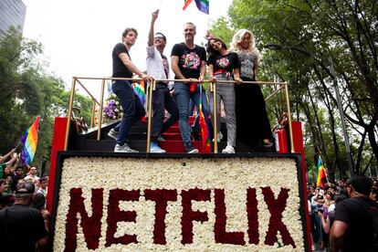 El elenco de la serie 'La casa de las flores', producida por Netflix, sobre un carro alegórico en el desfile de 2018.