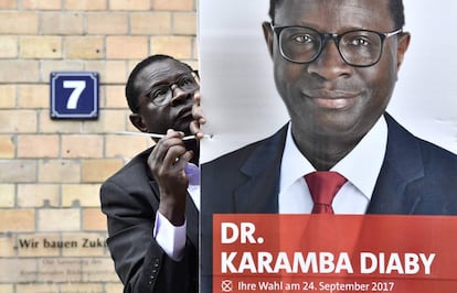 El diputado alemán del partido SPD nacido en Senegal, Karamba Diaby, coloca su cartel de campaña en una calle de Halle (Alemania).