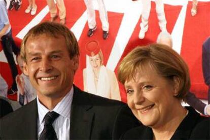 El seleccionador alemán, Jurgen Klinsmann, posa junto a Angela Merkel, canciller de Alemania.