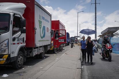 Dos mujeres caminan entre motocicletas ante la imposibilidad de movilizarse en transporte público por los bloqueos en la Autopista Sur de Bogotá.