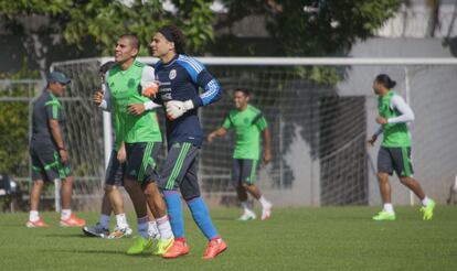 O goleiro Ochoa (meias azuis) e Salcido se aquecem no gramado, na última quarta.