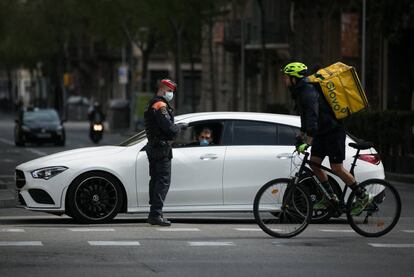 Un 'mosso' en un control a un vehículo en Barcelona este domingo.