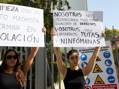 Dos alumnas del colegio mayor Santa Mónica, con dos carteles para protestar por los insultos recibidos por parte del Elías Ahuja, el jueves.