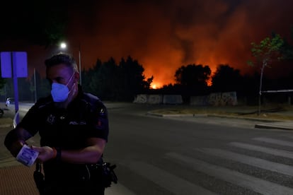 Un miembro de emergencias acota una zona cerca del incendio declarado en Tres Cantos.