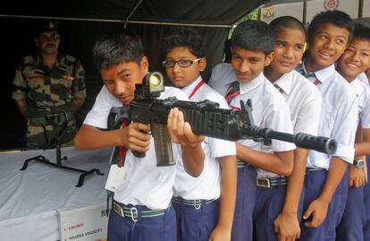 Un alumno de una escuela sujeta un rifle de asalto durante un programa organizado por Assam Rifles, una fuerza paramilitar para atraer a los jóvenes a unirse a la organización, en Agartala (India).
