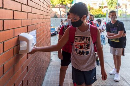 Un alumno se pone gel hidroalcohólico en la escuela rafael Casnova de Badalona antes de entrar en el centro.