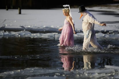 Una pareja disfrazada camina dentro del lago congelado Orankesee durante un evento llamado 'Carnaval Helado' en Berlín (Alemania).