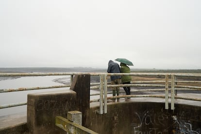 A couple watches the long-awaited rain, which fell this past week. However, the few hours of water made little difference in the reservoir’s levels. 