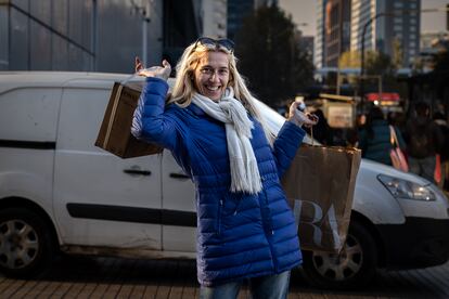 Una turista argentina posa con sus compras en las afueras de un concurrido centro comercial, en Santiago, Chile, el 17 de Mayo de 2024.