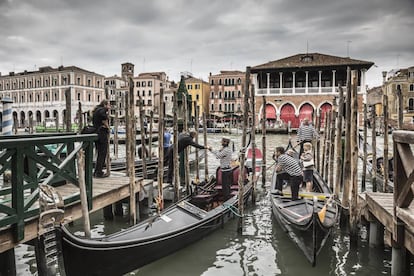 Gondoleros en el Gran Canal, con el edificio neogótico del mercado de pescados de Rialto al fondo, proyectado por el arquitecto Domenico Rupolo y el pintor Cesare Laurenti en 1907