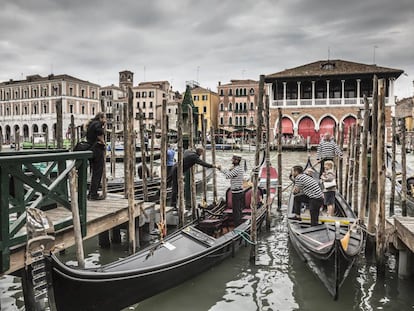 Gondoleros en el Gran Canal, con el edificio neogótico del mercado de pescados de Rialto al fondo, proyectado por el arquitecto Domenico Rupolo y el pintor Cesare Laurenti en 1907