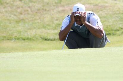 Tiger Woods estudia cómo dar un golpe en el hoyo nueve.