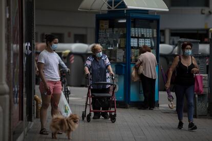 Varias personas pasean por una calle de Barcelona