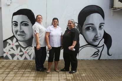 De izquierda a derecha, Pilar Feito, María Dolores Macías y María José Mármol posan ante dos de sus grafitis en Córdoba.