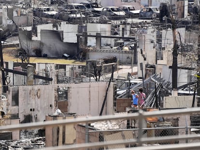 Dos personas examinan los restos de viviendas calcinadas por el incendio que ha destruido la ciudad histórica de Lahaina en la isla hawaiana de Maui.