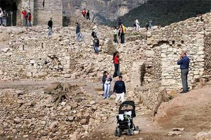 Decenas de turistas deambulando, ayer, entre los restos del pueblo anegado hace 42 años.