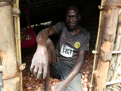 Raja Amimo, agricultor mozambiqueño, junto al granero en el que guarda su reciente cosecha de cebollas.