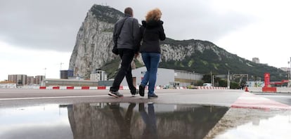 Two people cross the airport of Gibraltar.