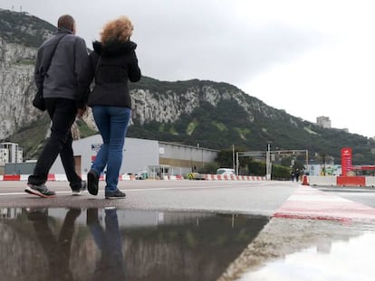 Two people cross the airport of Gibraltar.