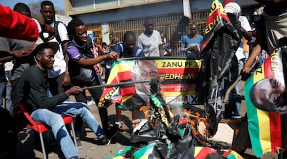 Simpatizantes del Movimiento para el Cambio Democrático (MDC) queman pancartas con la cara del presidente del país, Emmerson Mnangagwa, este lunes en Zimbabue.