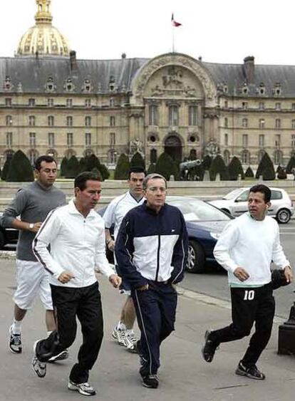 El presidente colombiano, Álvaro Uribe, corre rodeado de guardaespaldas ante Los Inválidos, en París.