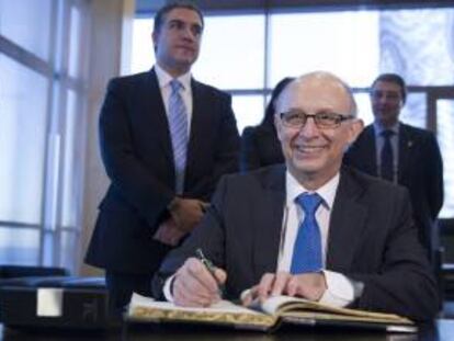 El ministro de Hacienda, Cristobal Montoro firma en el libro de autoridades durante su visita a la Diputación de Málaga.
