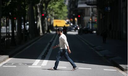 Un home creua el carril lateral de la Gran Via de Barcelona, on es tallarà el trànsit per donar espai als vianants.